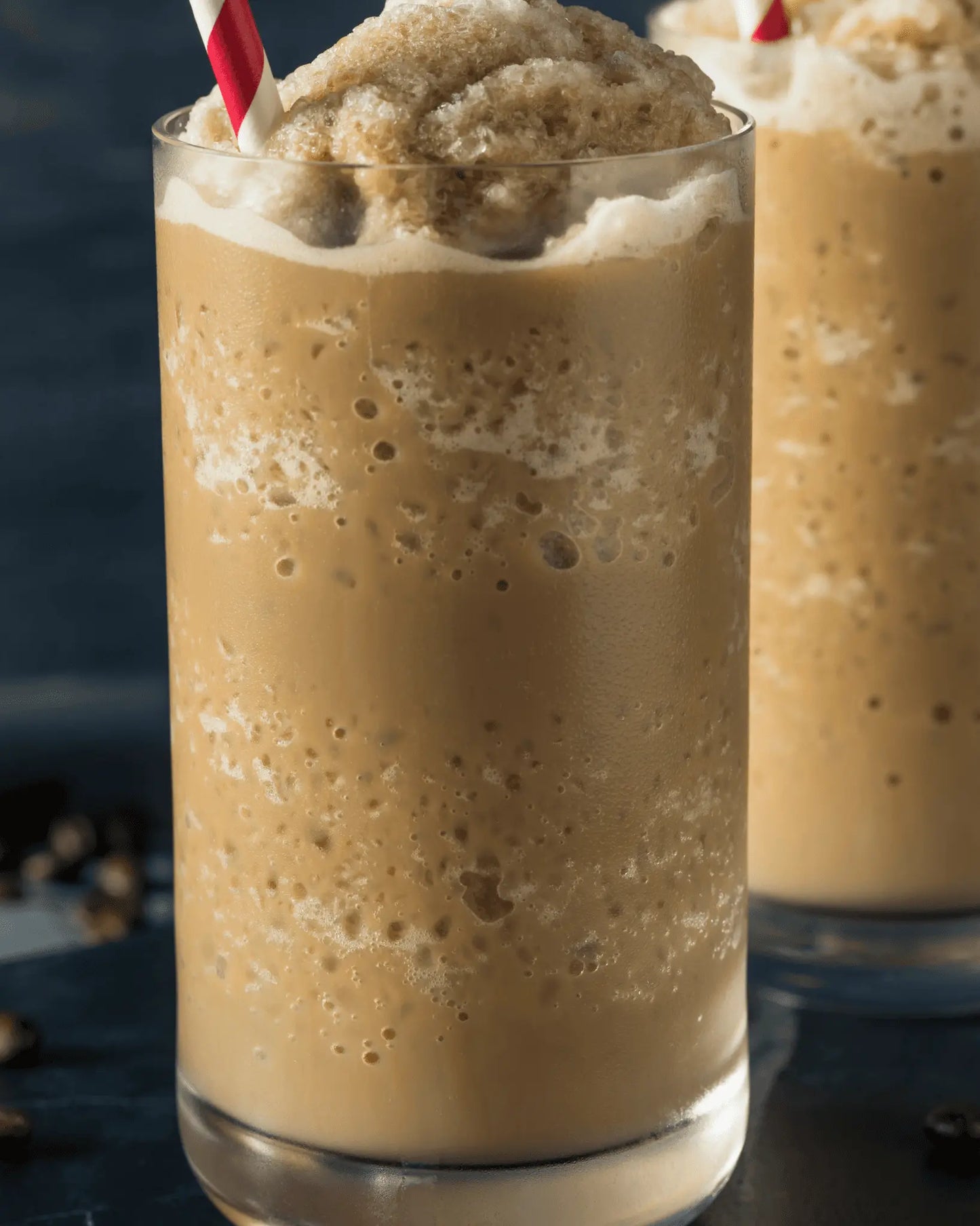 Iced coffee blended drink made with premium coffee powder, topped with whipped cream and a straw