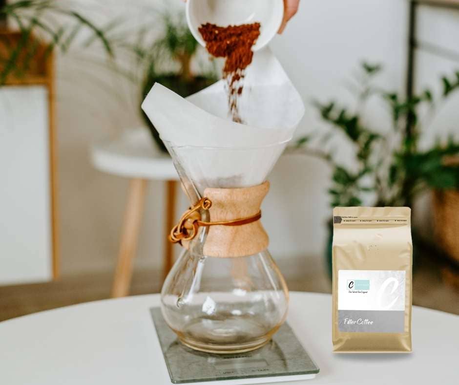 Brewing handcrafted filter coffee using a glass Chemex with freshly ground coffee beans