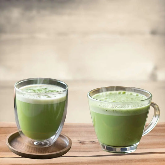Two cups of pure matcha tea served in glass mugs on a wooden surface