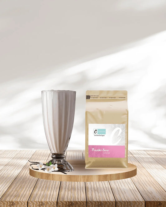Caffeeegy.Co best vanilla powder for lattes displayed with a glass of creamy vanilla latte on wooden surface