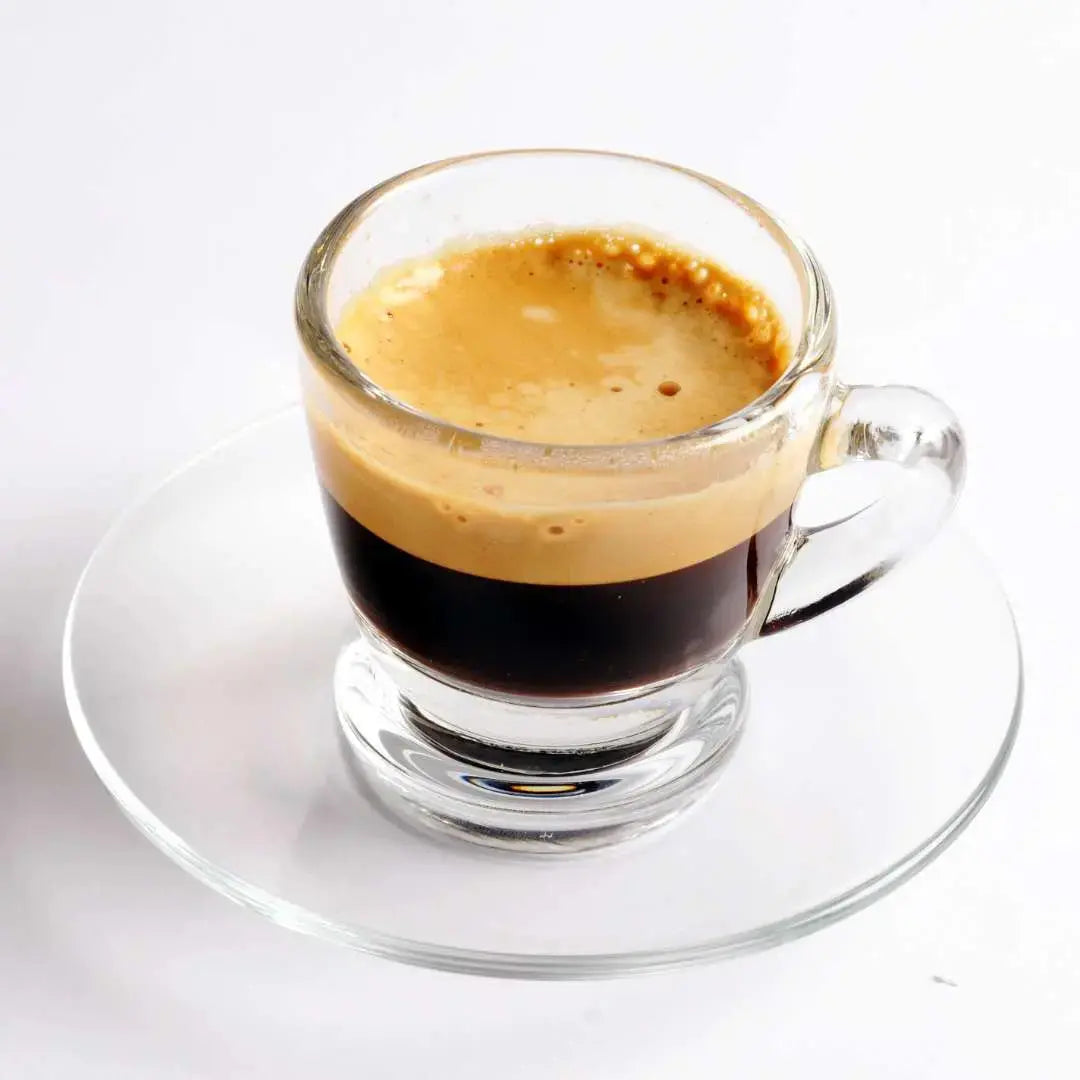 Caffeeegy.Co premium espresso coffee blend served in a clear glass cup on a glass saucer