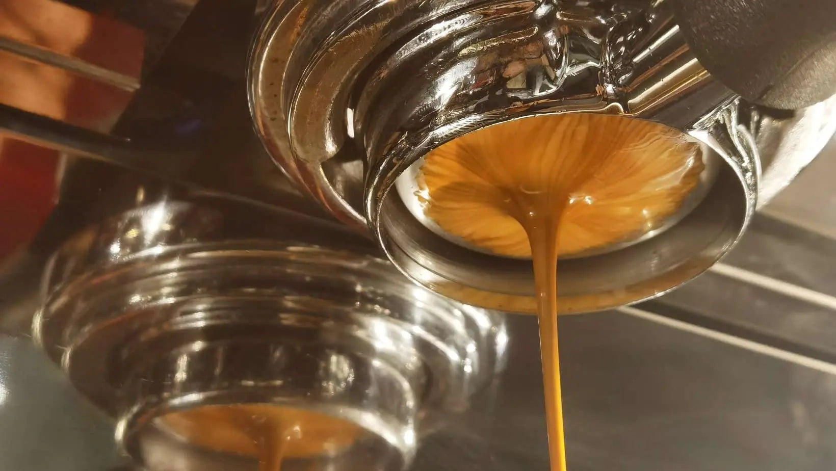 Close-up of espresso machine pouring premium espresso coffee blend with rich crema from Caffeeegy Co