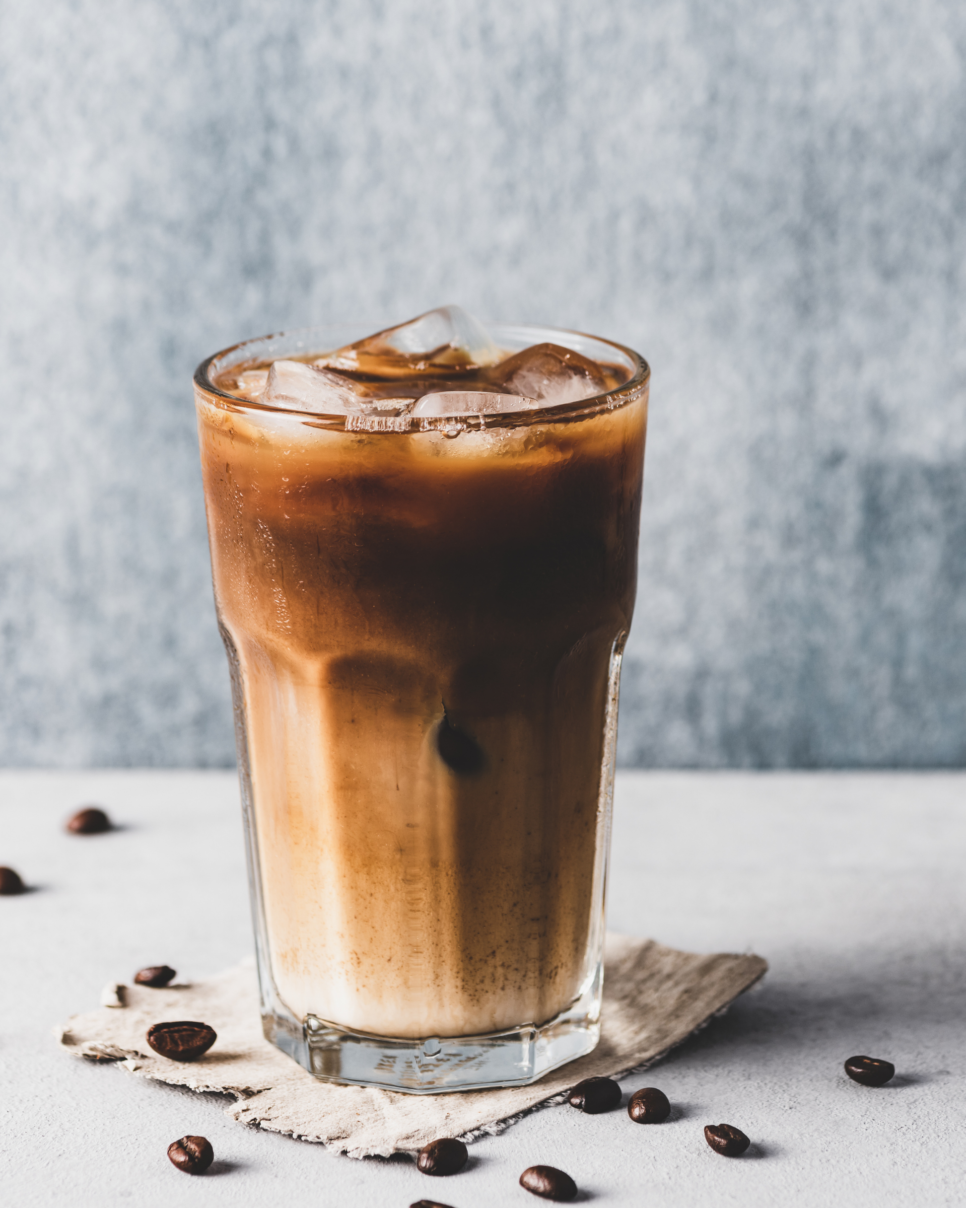 Glass of iced coffee with milk and ice cubes representing the best ice coffee in Egypt by Caffeeegy Co