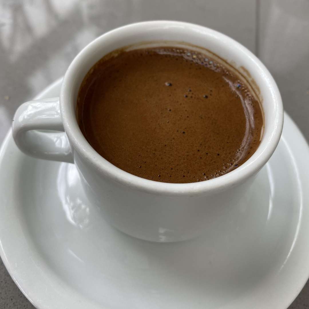 Cup of freshly roasted Turkish coffee served in a white porcelain cup on a saucer